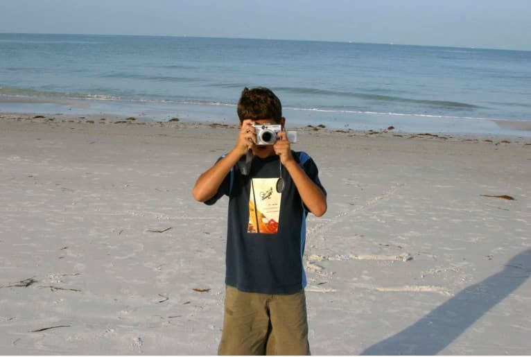 Young Hunter on a white-sand Florida beach holding his first camera