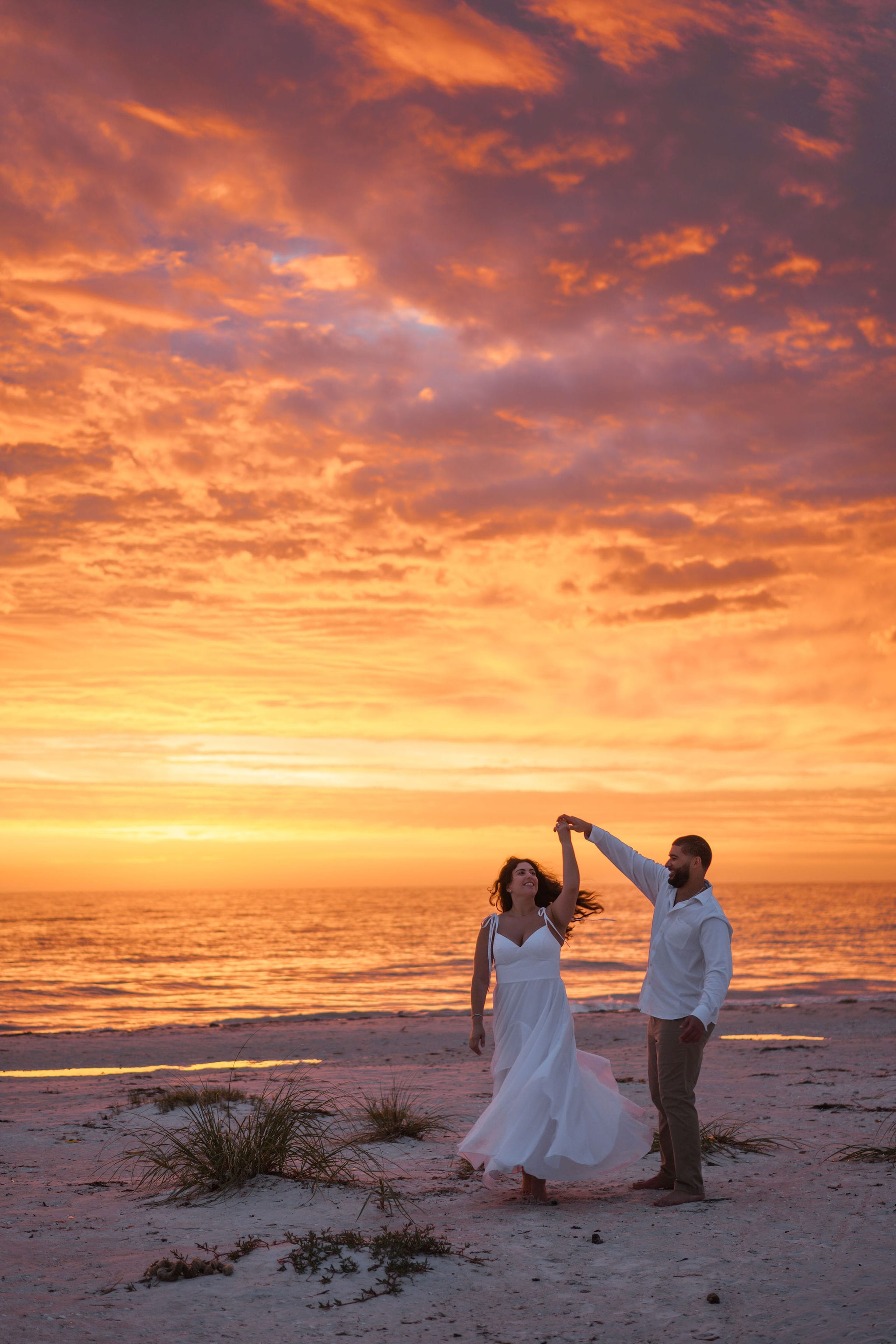 Couple twirl flowing dress sunset beach florida