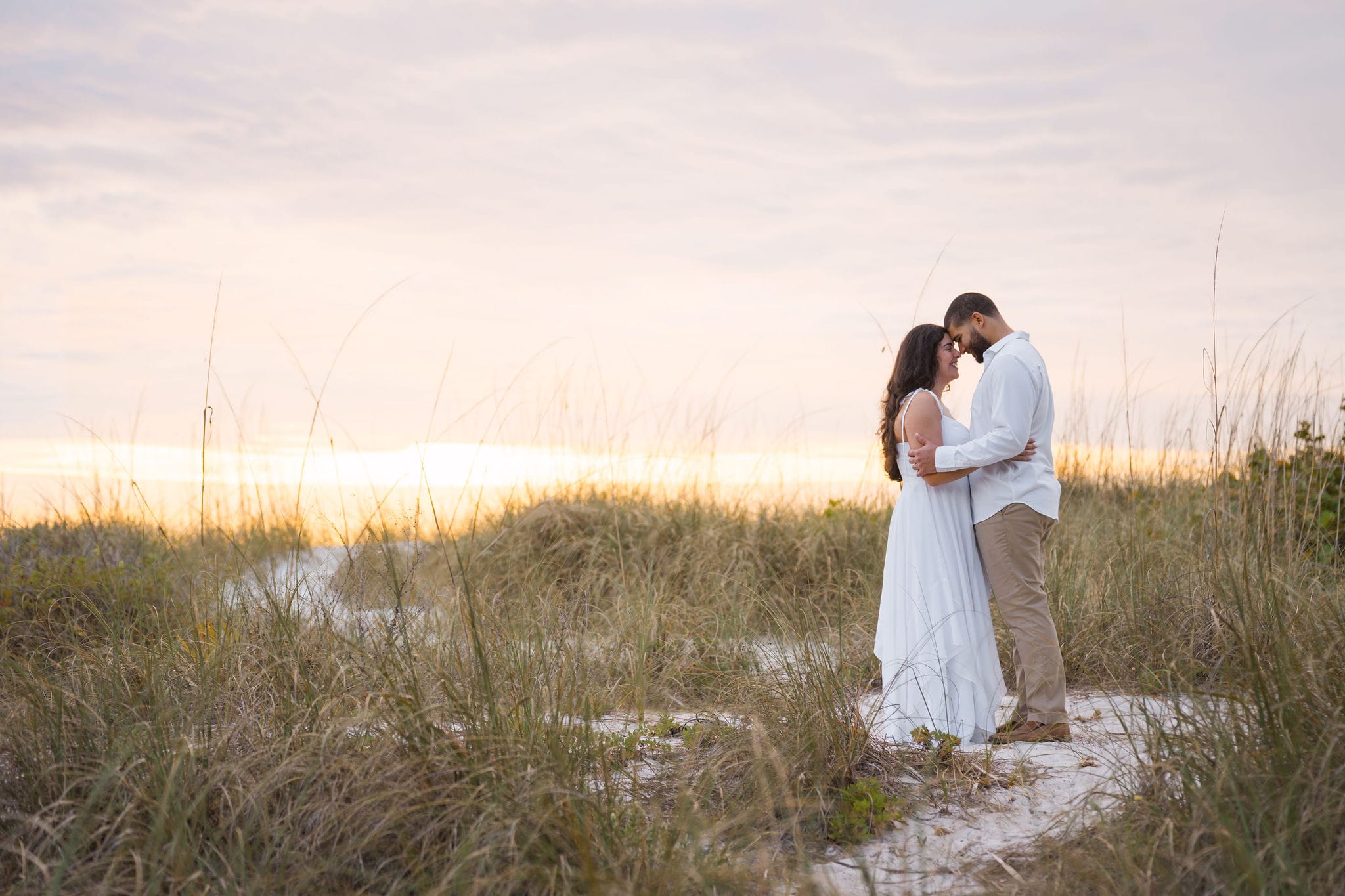 Couple dune grass foreheads pastel sunset