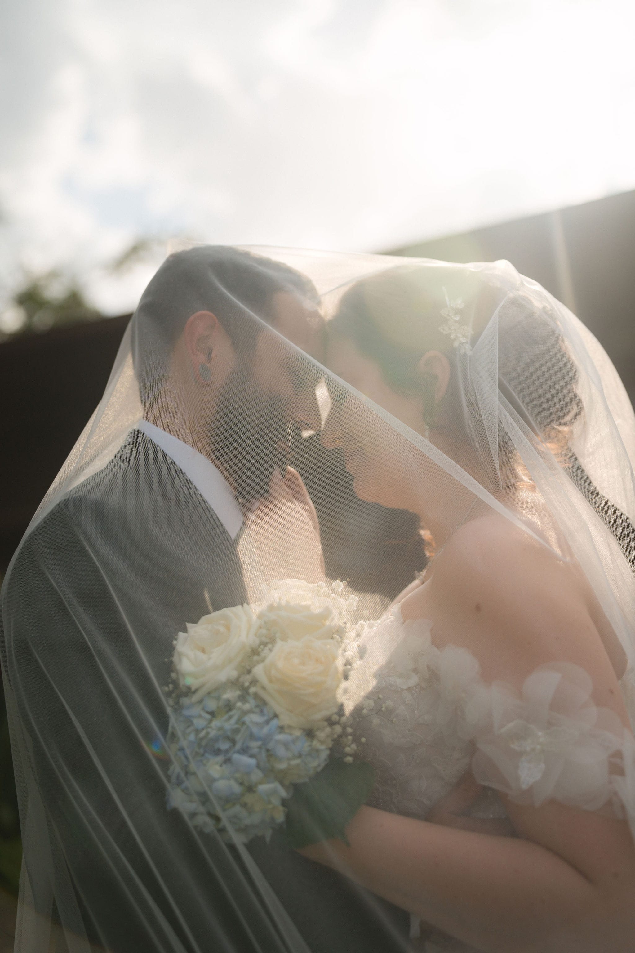 Backlit couple sheer veil sun flare