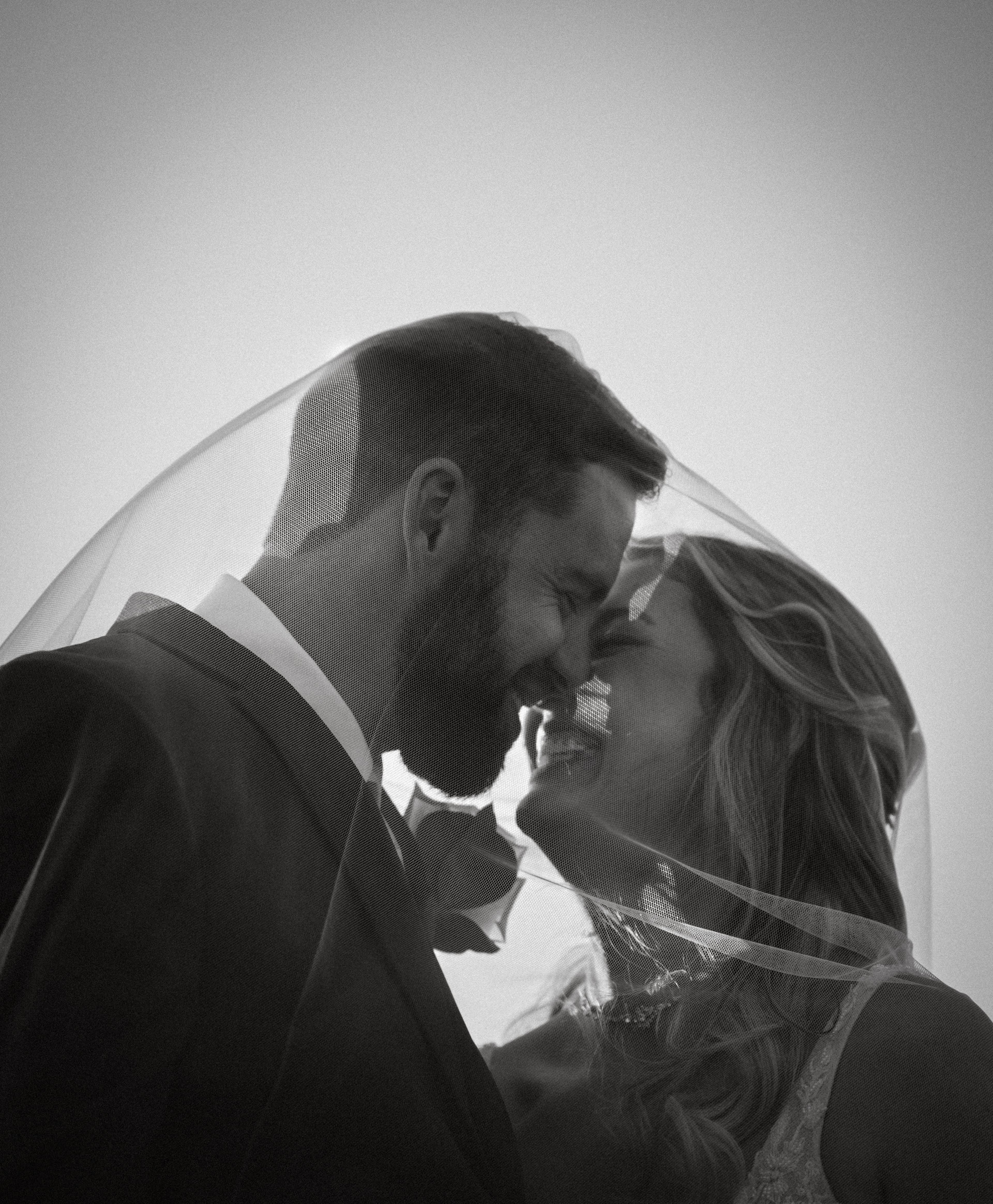 Black and white veil couple nose to nose