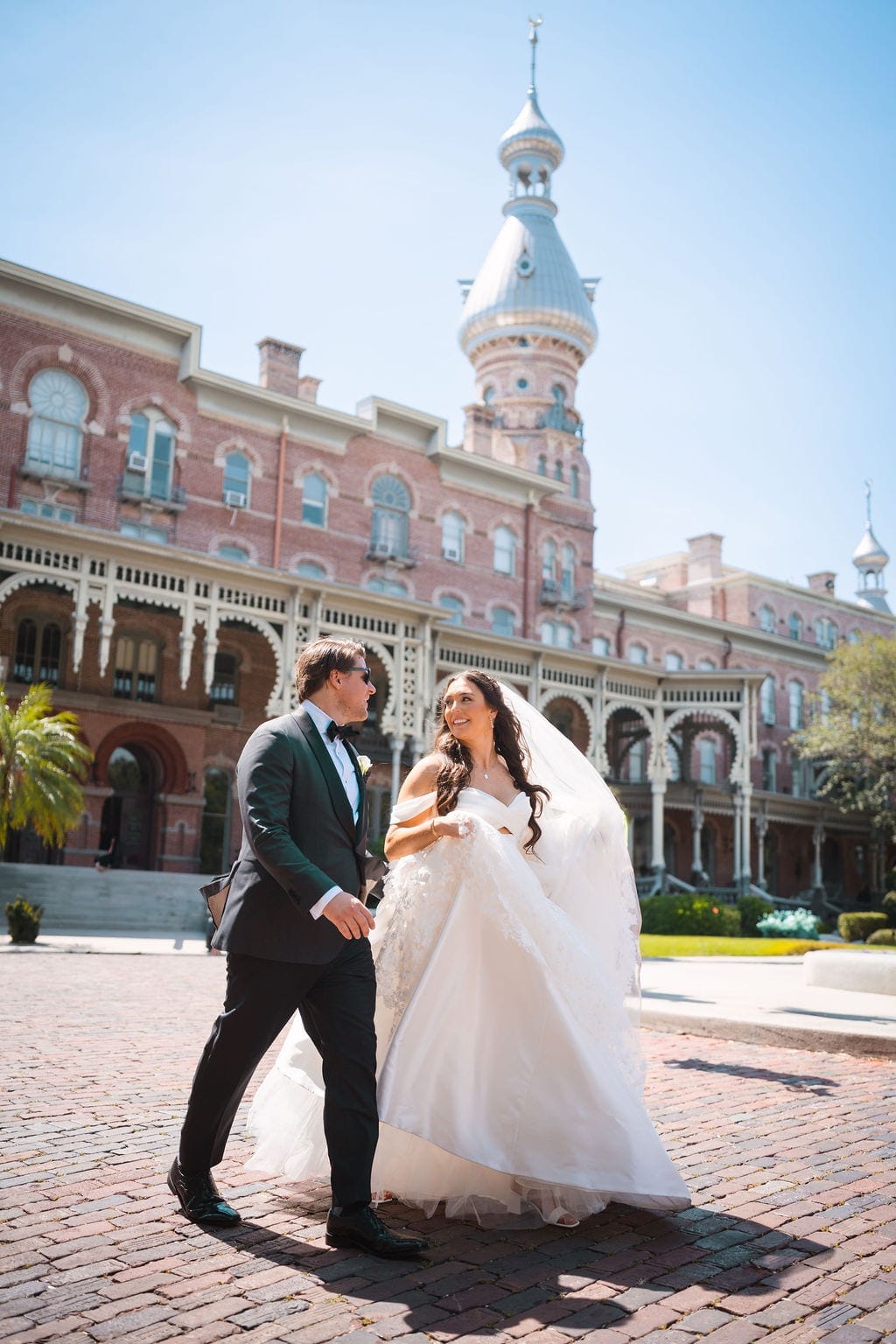 Bride and groom walking brick courtyard University of Tampa