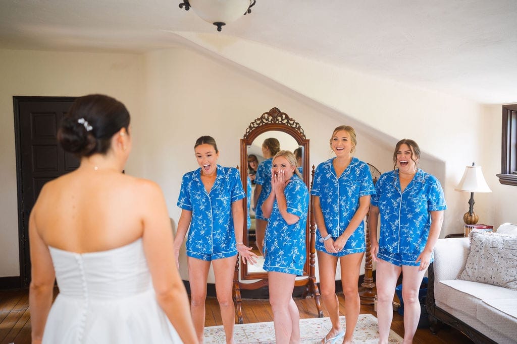 Bridesmaids reacting to bride in dress blue pajamas