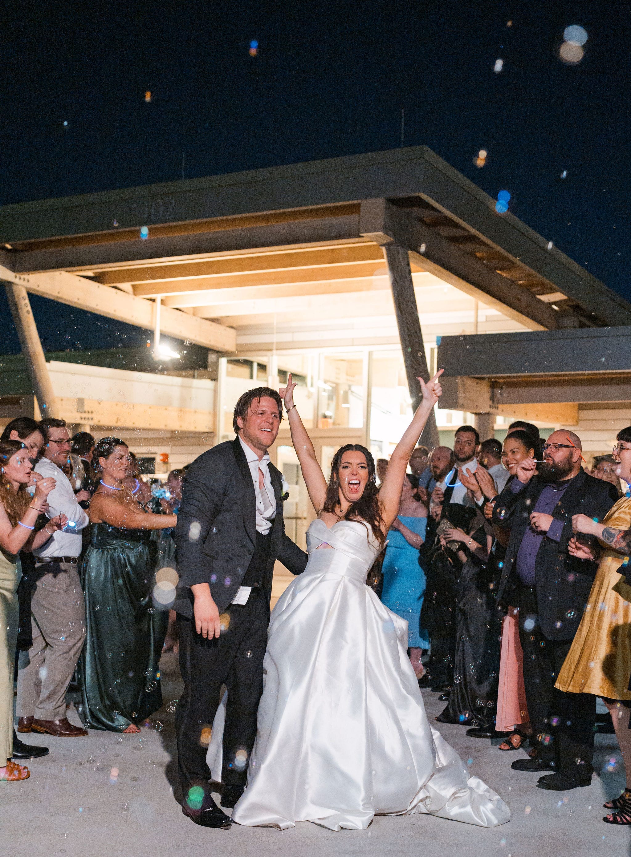 Nighttime bubble tunnel cheering newlyweds