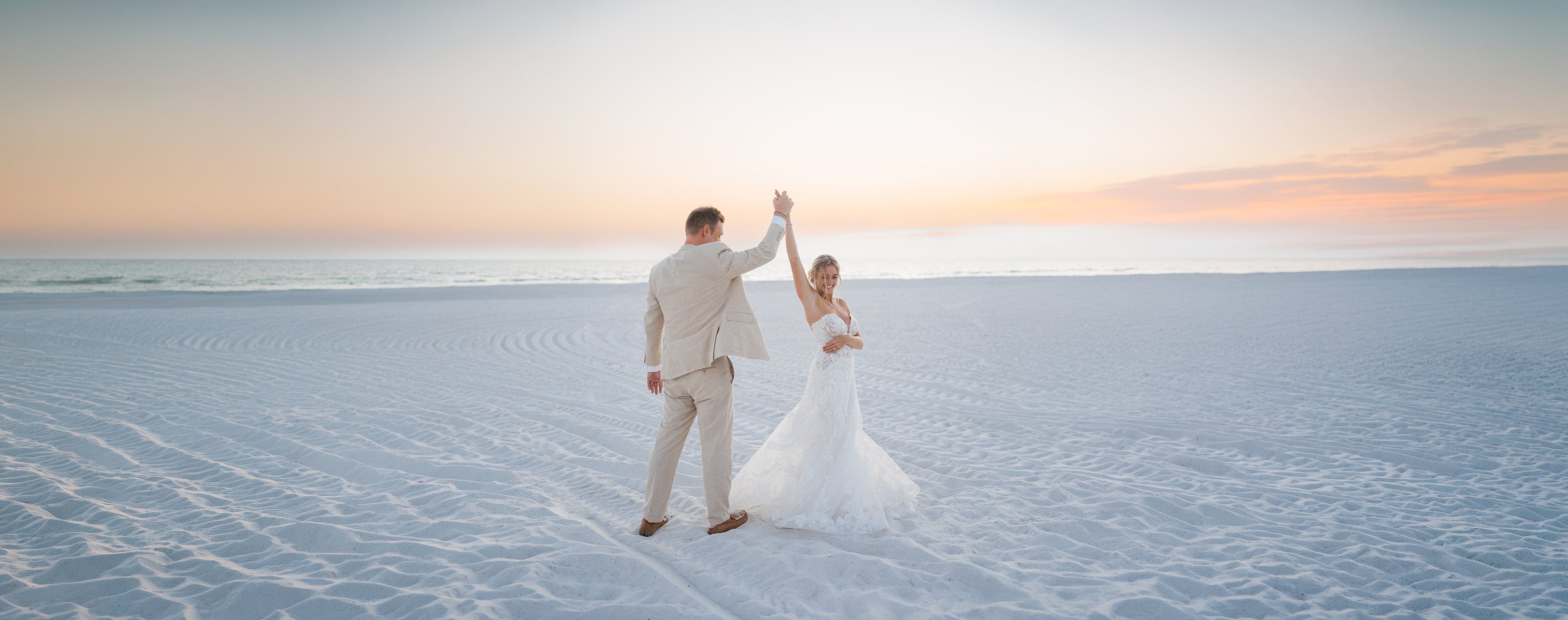 Groom twirling bride sunset beach florida wedding