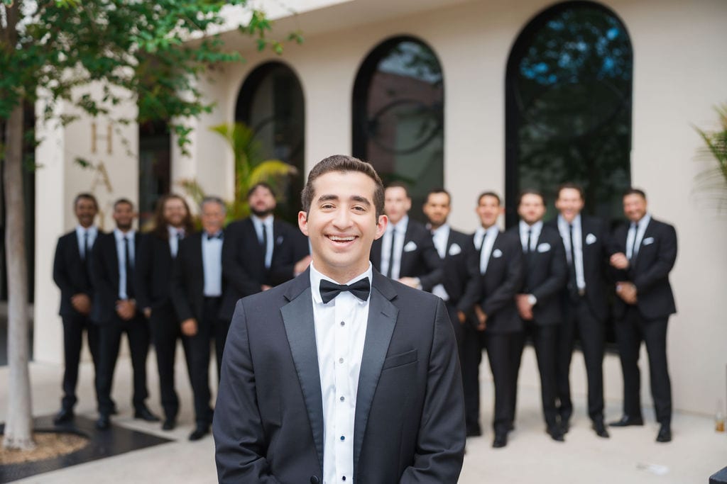 Groom laughing groomsmen arched windows