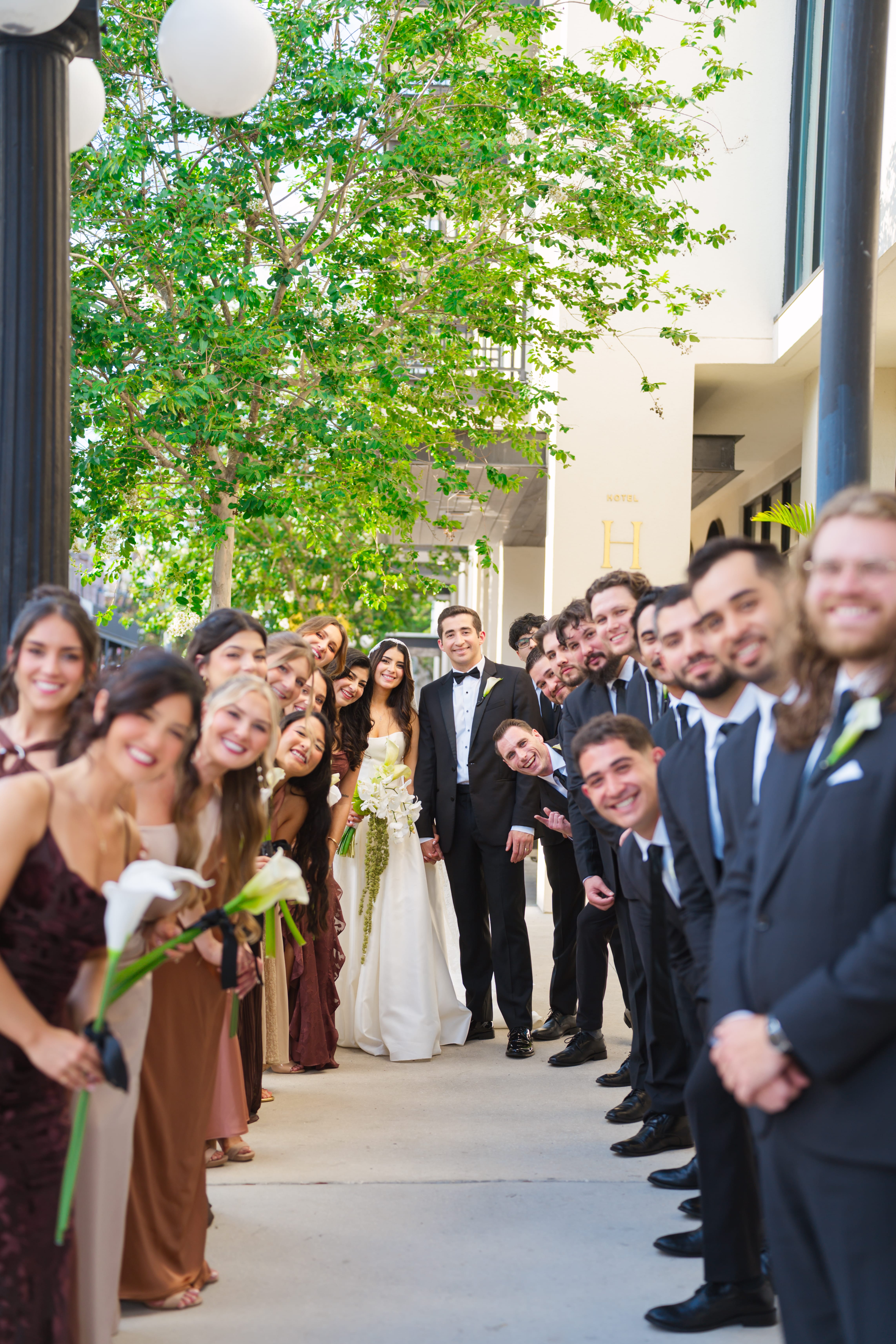 Wedding party lining sidewalks newlyweds