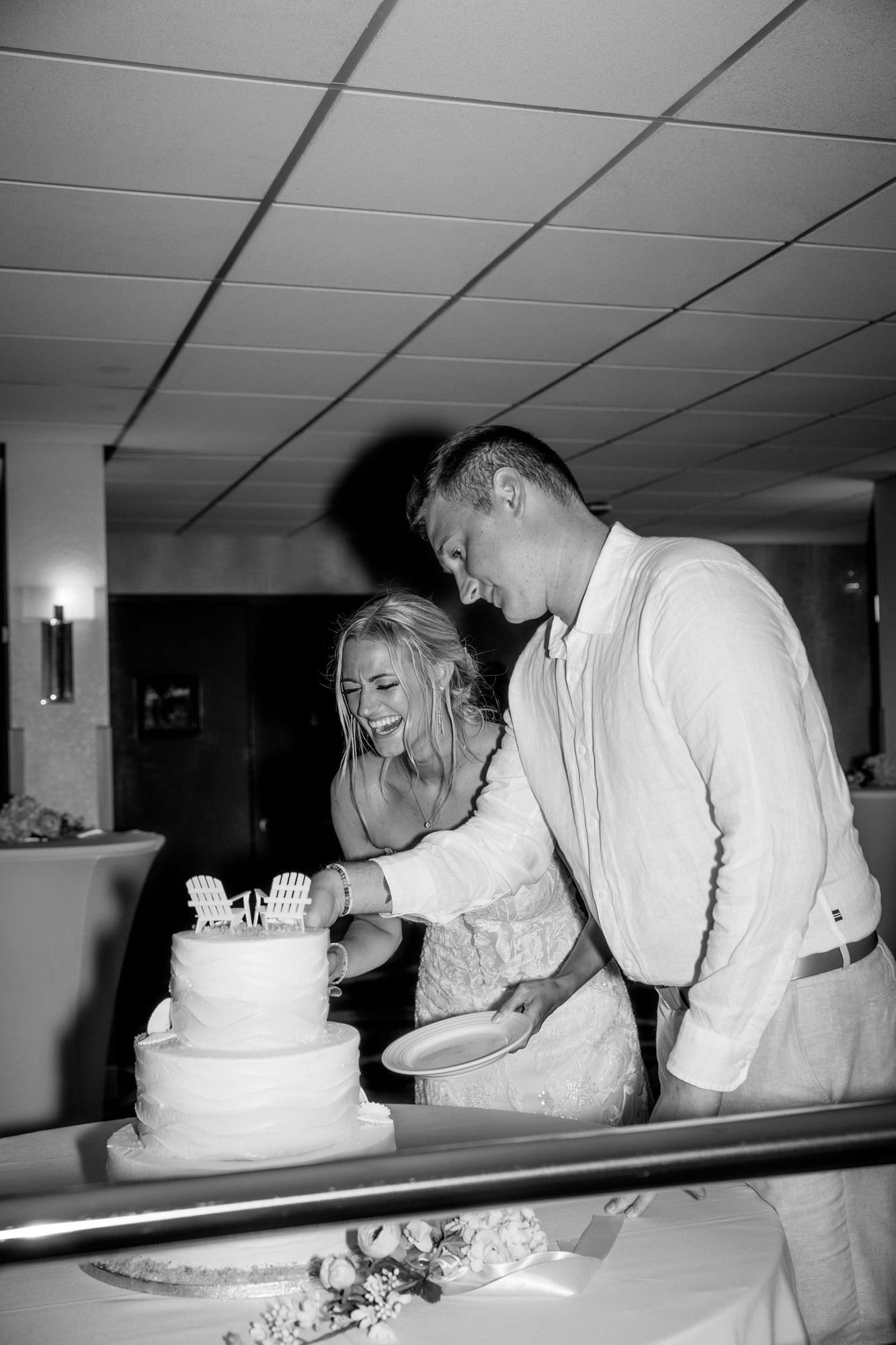 Black and white photo of a bride and groom cutting their wedding cake