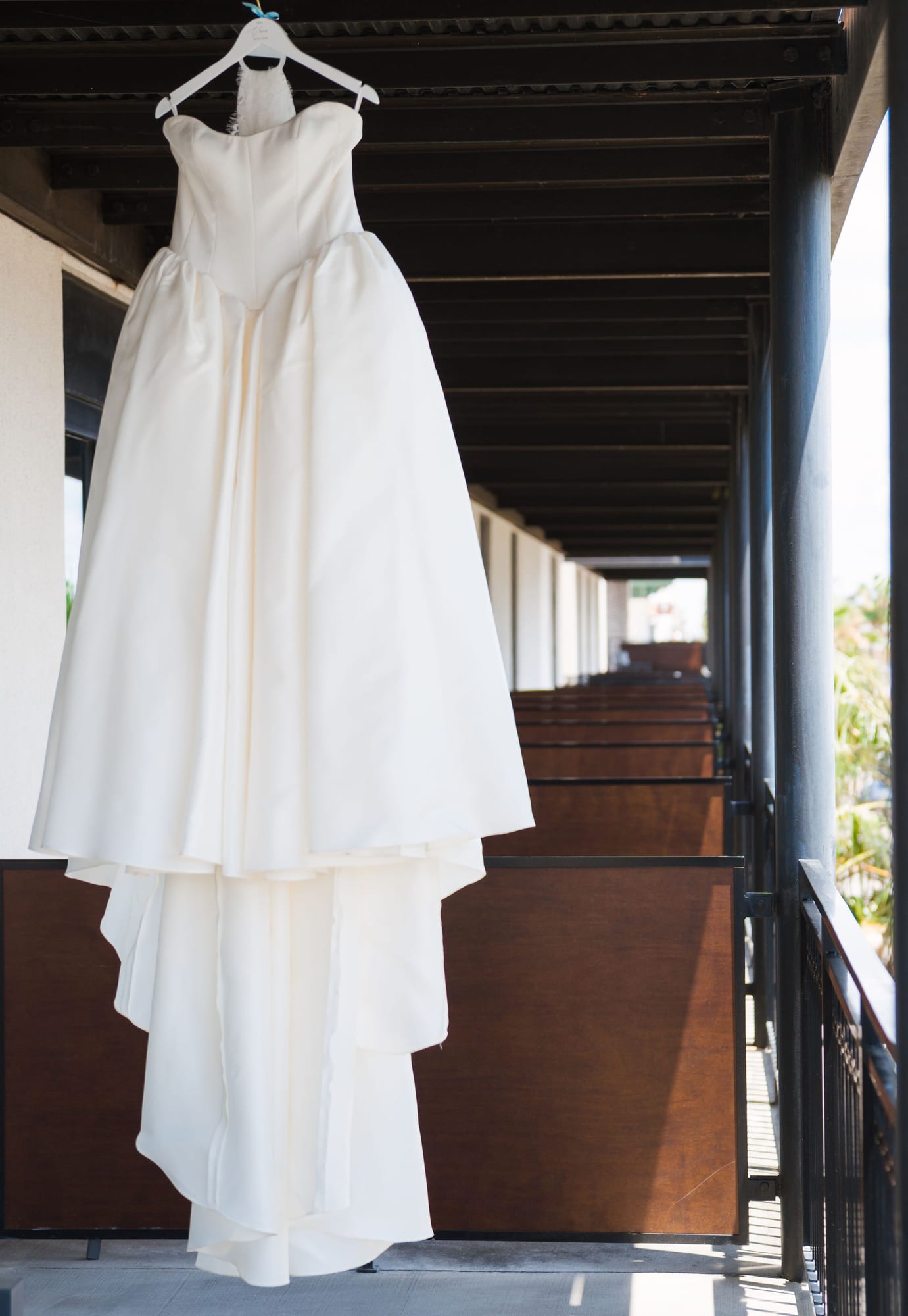 Wedding dress hanging outdoors on a balcony before the ceremony