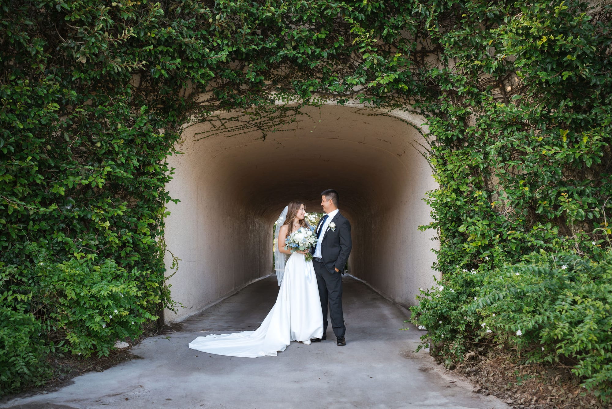Bride and groom embracing inside the ivy covered archway at Lakewood Ranch Golf and Country Club