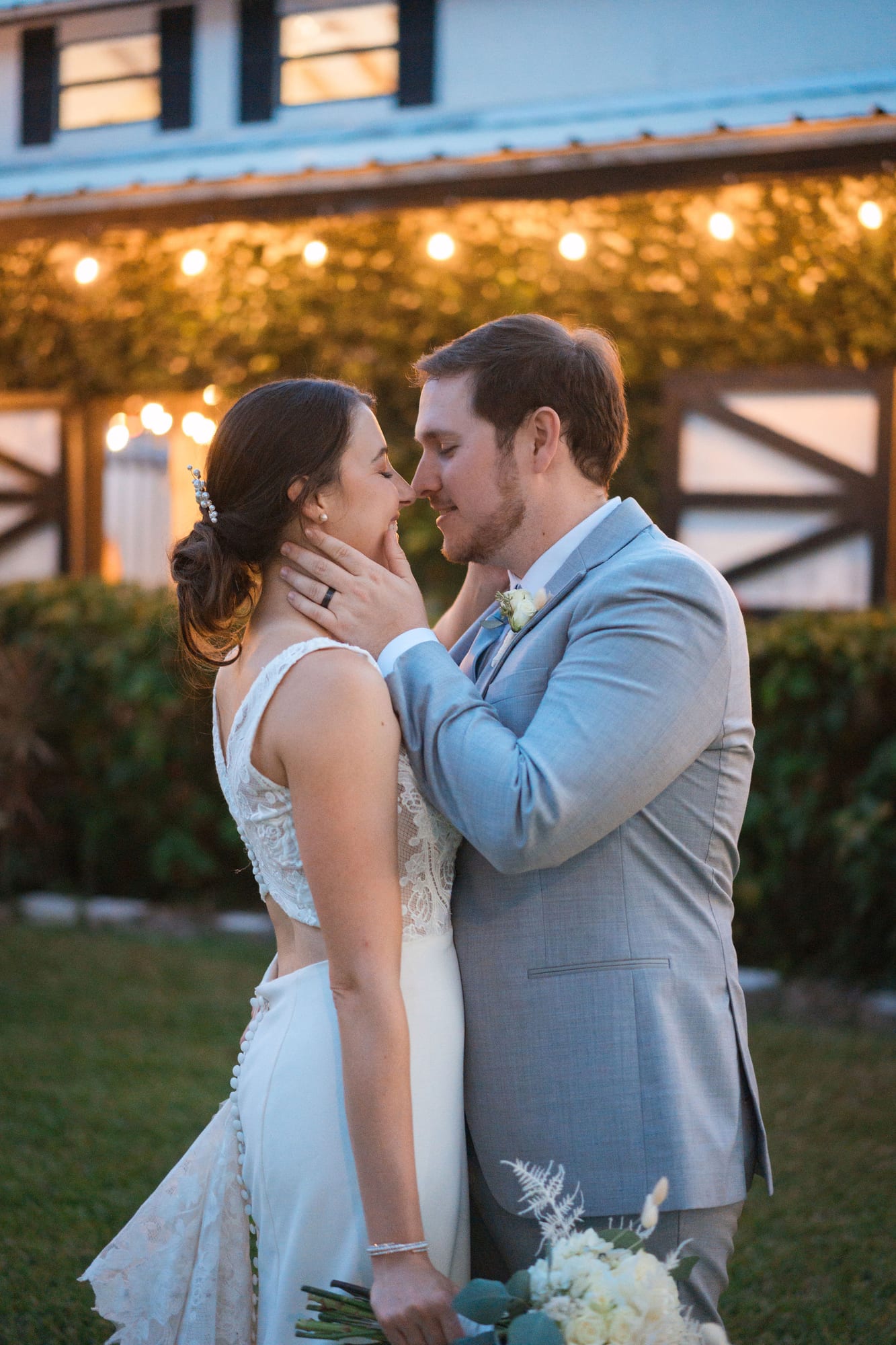 Bride and groom at golden hour in front of the ivy wall and string lights at SoireEstate