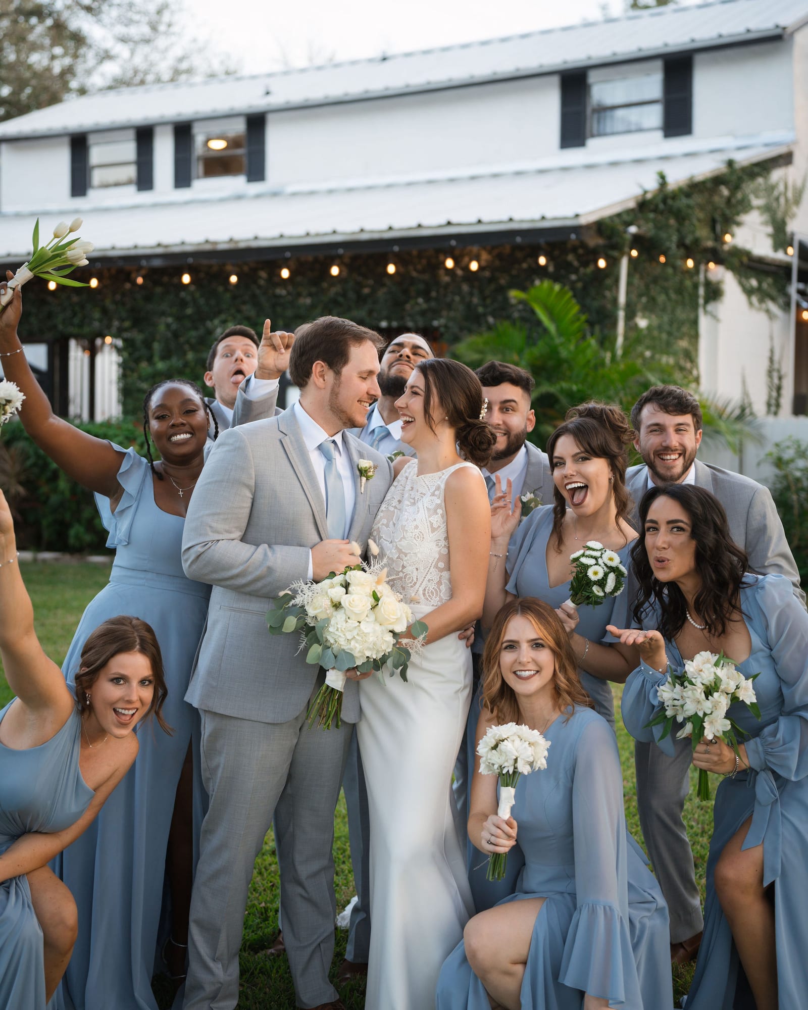 Wedding party celebrating with the bride and groom outside the Stable House