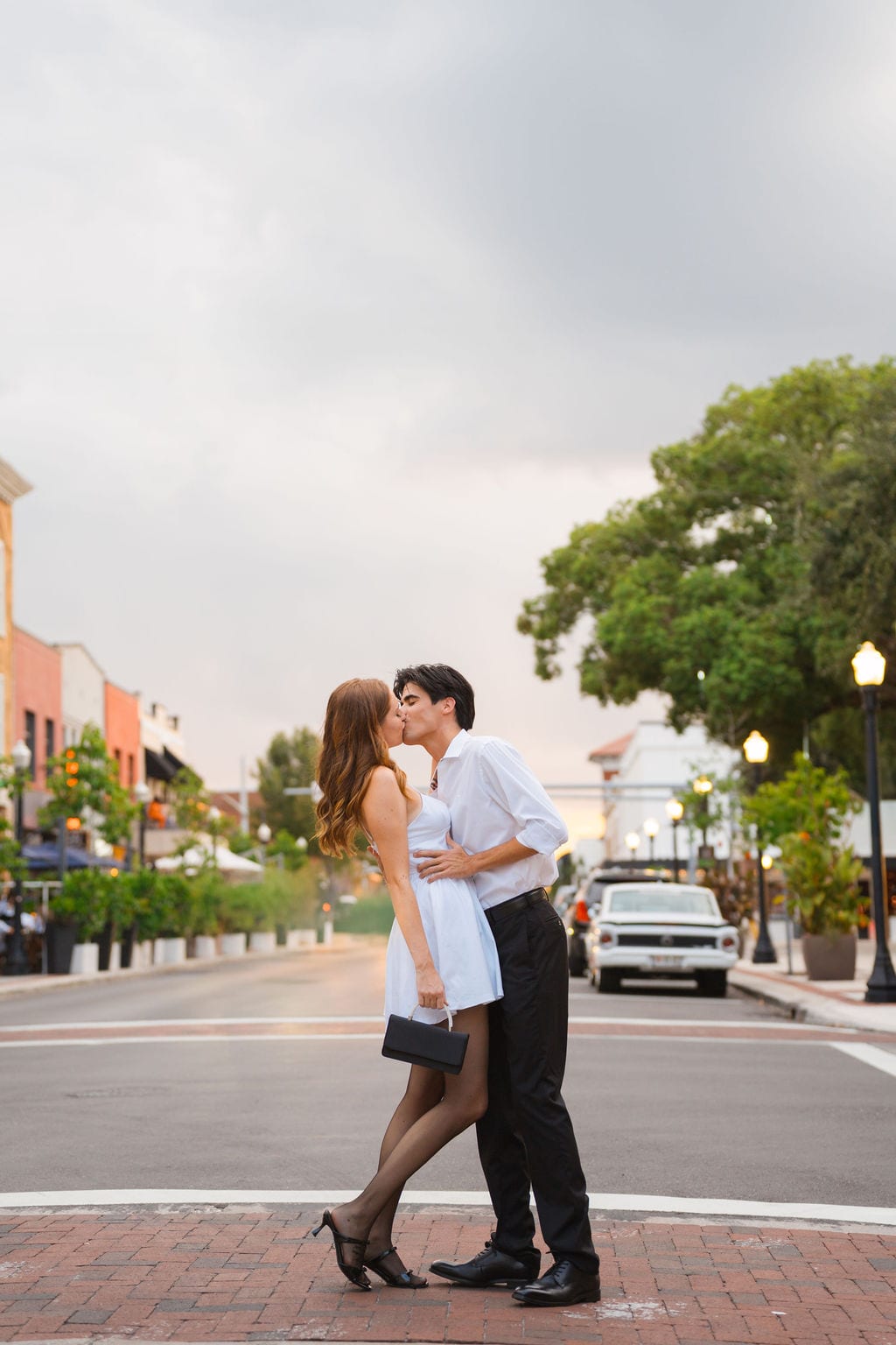Couple kissing in an empty downtown street at dusk during a St. Petersburg engagement session
