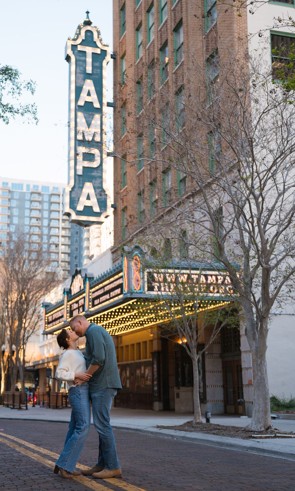 Couple kissing under the Tampa Theatre marquee in downtown Tampa at night