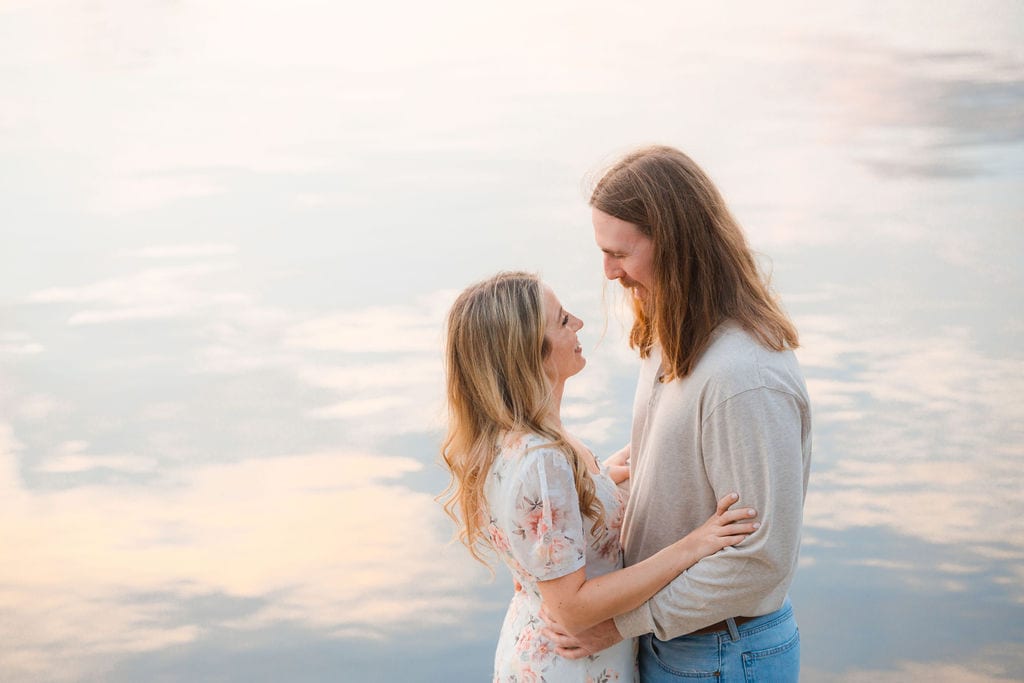 Couple laughing face to face at a pastel lake sunset near Sarasota