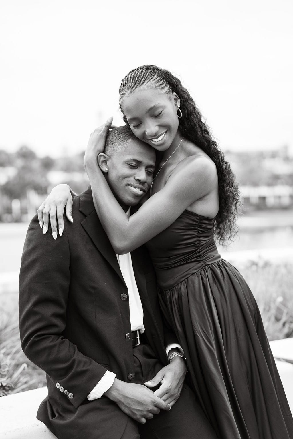 Black and white photo of a couple hugging and laughing at the Tampa waterfront