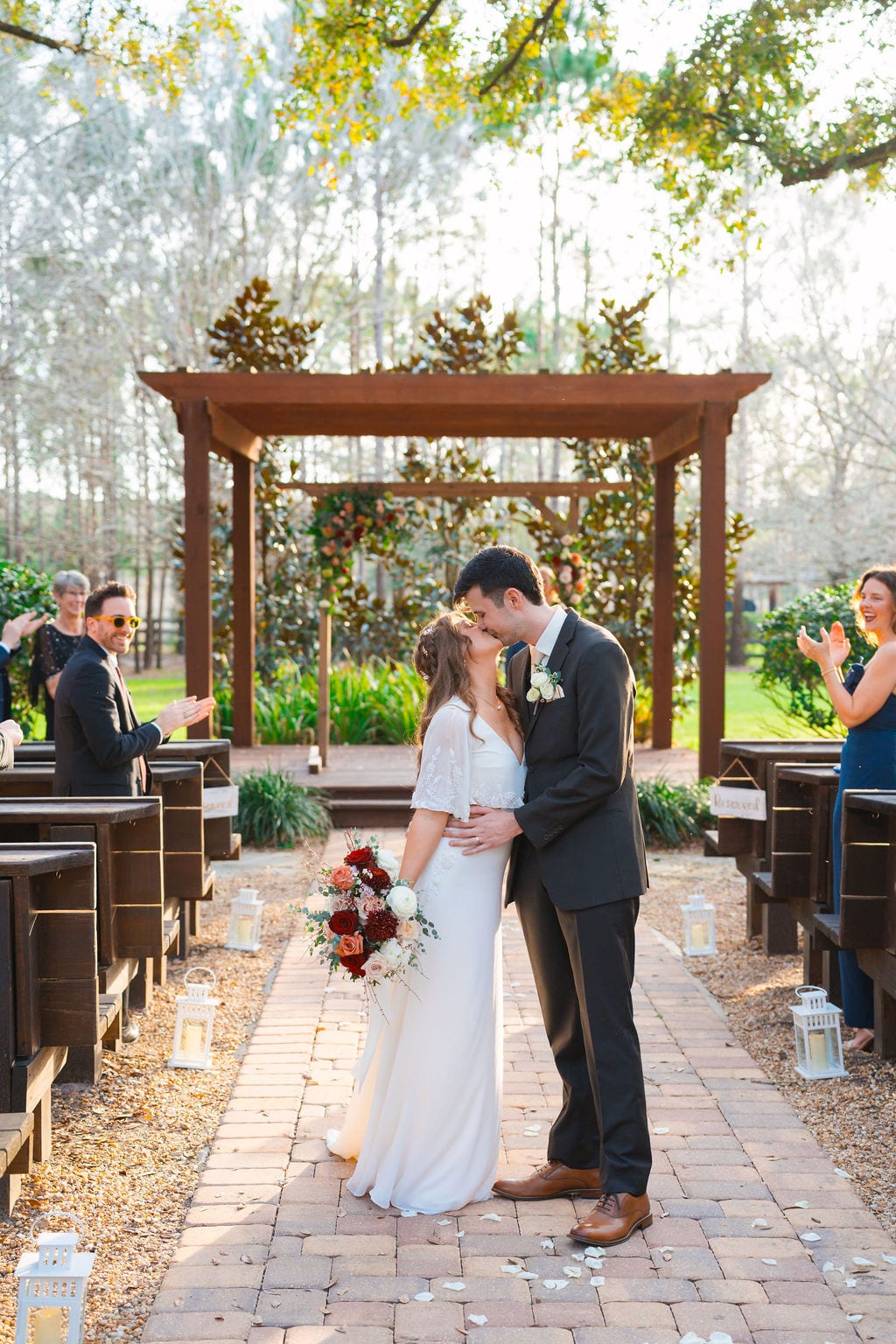 Bride and groom kissing in the aisle after an outdoor wedding ceremony