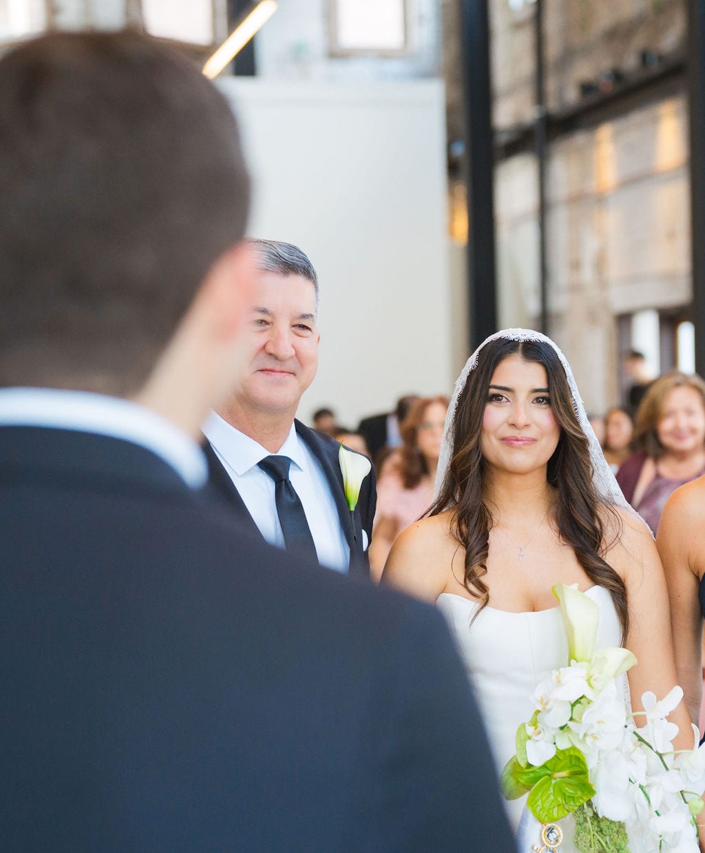 Bride walking down the aisle with her father toward the groom during the ceremony