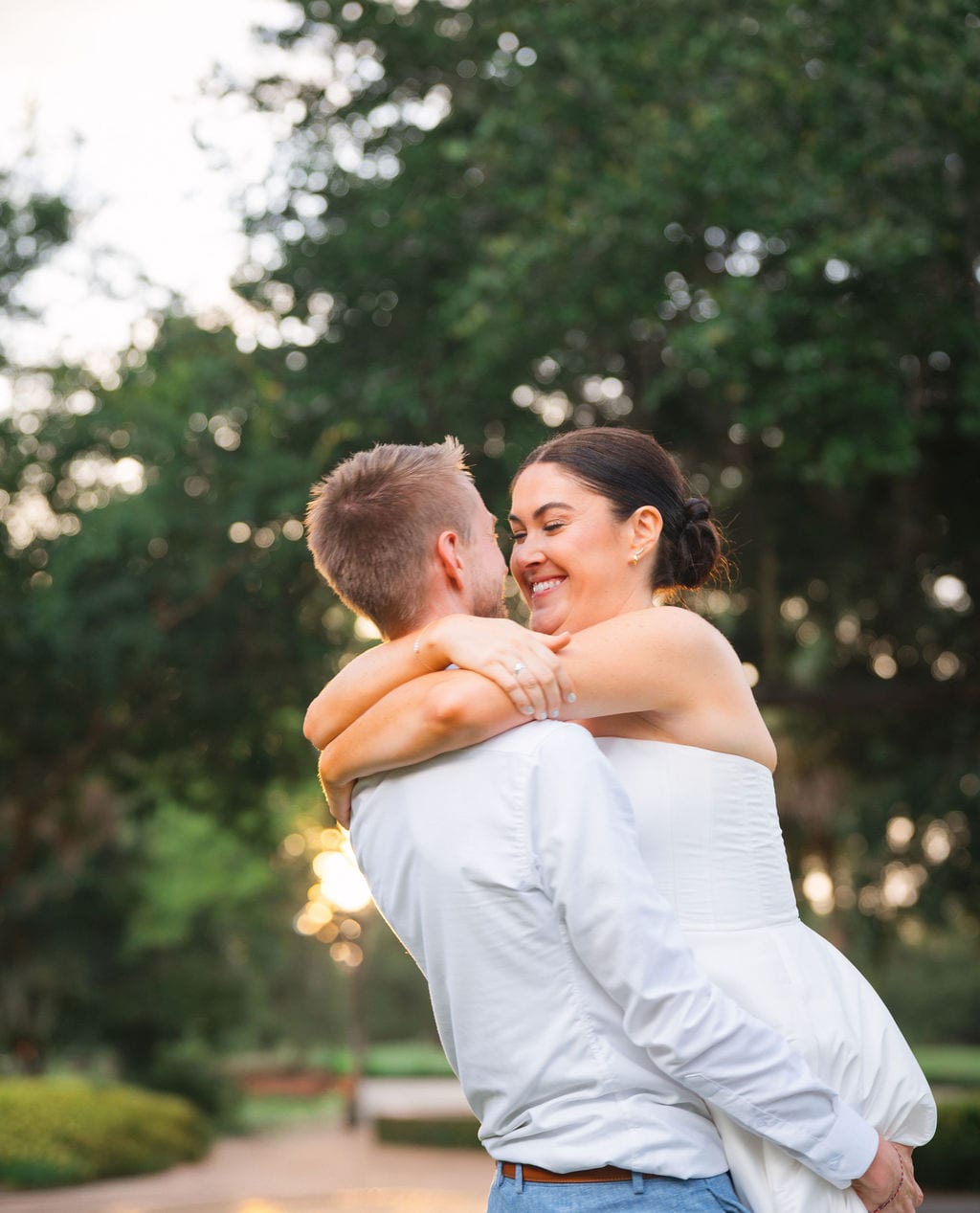 Groom lifting bride during golden hour in a garden at a Florida wedding