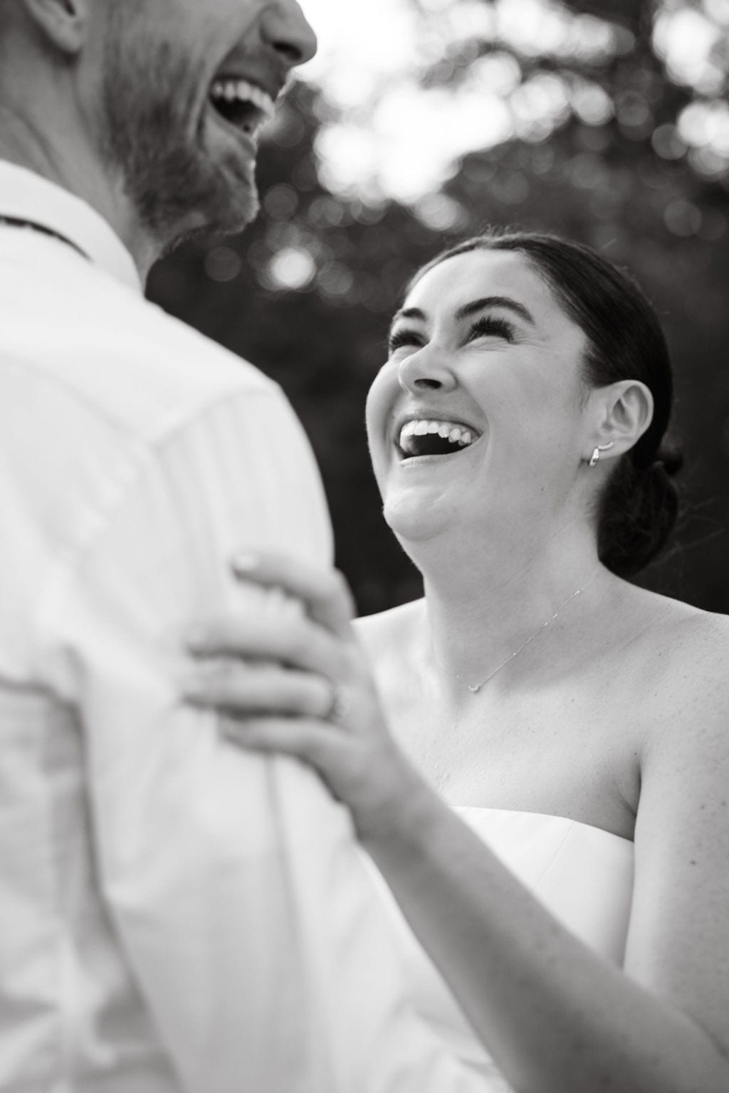 Bride laughing with her groom in a black and white portrait
