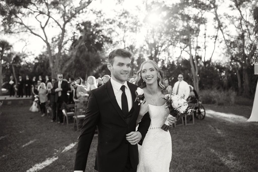 Bride and groom just married, backlit under oaks in black and white