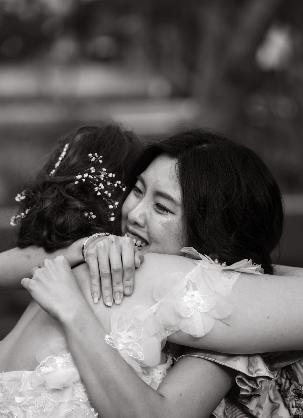 Bride hugging a crying loved one at a wedding, black and white